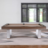Contemporary slate pool table with clean walnut finish and sculptural steel legs, positioned against textured accent wall in upscale entertainment space