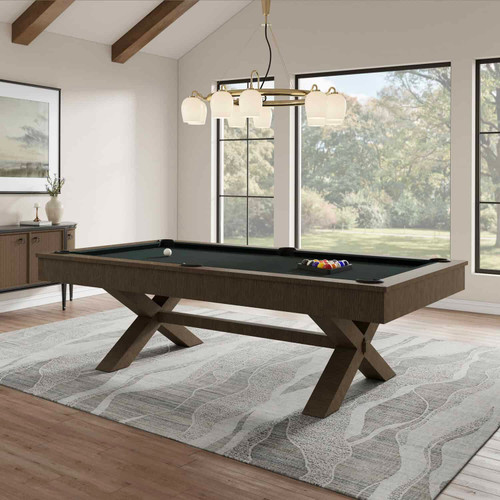 The Crissycross Billiard Table is shown fully staged in a contemporary game room with natural lighting. The bold charcoal finish and sculptural leg design create a refined but modern atmosphere.

