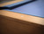Close-up detail of the Paula Parsons pool table rail showing mother-of-pearl diamond-shaped billiard sights, solid maple construction, and Academy Blue felt for tournament-quality play.
