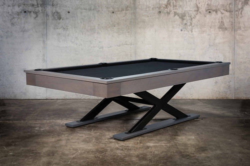 his hero shot of The Metalsmith pool table by Doc & Holliday captures the table in its full glory within a luxurious game room setting. The image highlights the sleek, oversized X-legs and the prominently displayed steel logo, reflecting the table's robust industrial design.
