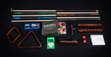 The Plank & Hide Classic Billiards Accessory Kit displayed on a white background, including pool balls, cues, cue rest, rack, brush, vinyl cover, and more, highlighting the premium quality and craftsmanship.