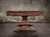 A focused look at the trestle-style base in Distressed Brown, showing its grounded stability and sculptural crossbeam. The subtle distressing in this view adds to its lived-in warmth.