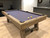 Isaac Pool Table installed in a sleek executive office lounge with brushed metal fixtures and custom cabinetry. This image reinforces its appeal in high-end commercial spaces like corporate break areas or client entertainment suites.