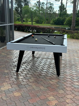 Top-down angle of the Manhattan Outdoor Pool Table placed in a contemporary outdoor space, showcasing the full slate playfield and smooth Sunbrella felt surface.

