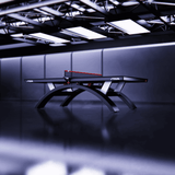 STIGA Paragon table tennis table in stealth black illuminated by built-in LED lighting, showcased in a futuristic studio inspired by sci-fi interiors with glowing floor panels and ambient blue lighting.

